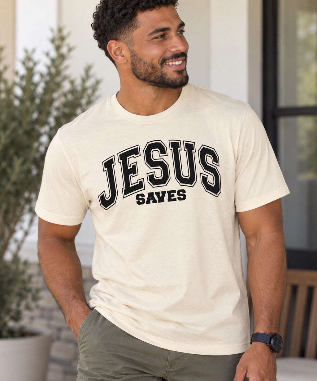 Model wearing a cream Jesus Saves T-shirt with black varsity lettering.