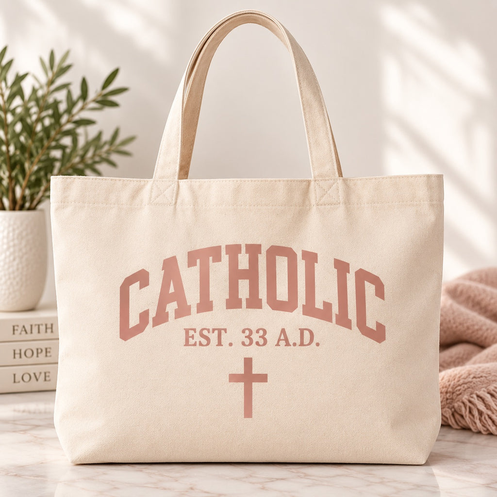 Cream tote bag with pink Catholic lettering, EST. 33 A.D. text, and a cross.