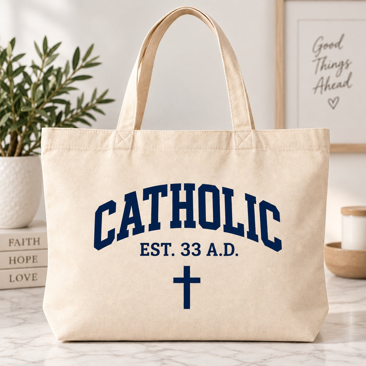 Cream tote bag with dark blue Catholic lettering, EST. 33 A.D. text, and a cross.