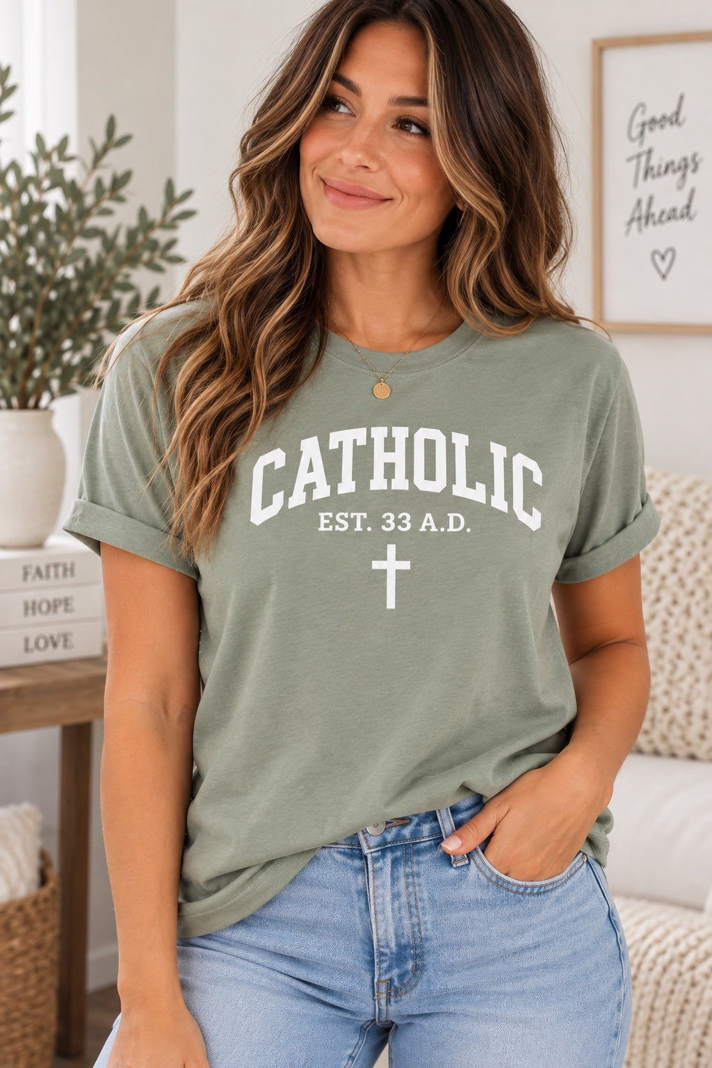 Model wearing a pale green T-shirt with white Catholic lettering, EST. 33 A.D. text, and a cross.
