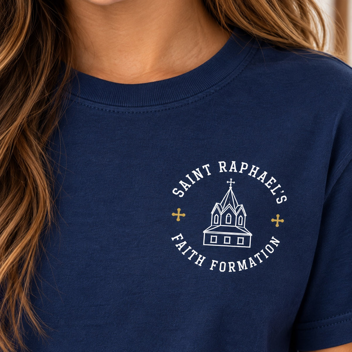 Close-up of the Saint Raphael’s Faith Formation design on the navy youth T-shirt