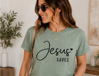 On-model mockup of a sage T-shirt with the Jesus Saves design in black lettering.