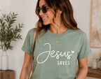 On-model mockup of a sage T-shirt with the Jesus Saves design in white lettering.
