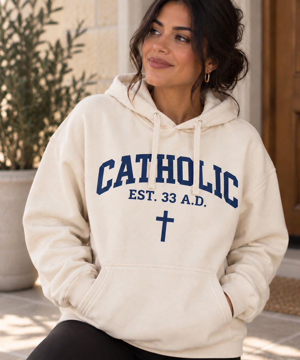 Women’s Catholic Varsity hoodie in natural with navy lettering