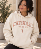 Women’s Catholic Varsity hoodie in natural with rose gold lettering